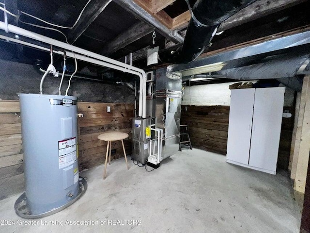 17669 Lake Dr, Barryton, MI 49305 - unfinished below grade area featuring water heater, wood walls, and heating unit