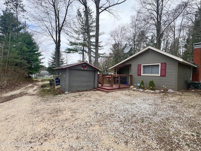 17669 Lake Dr, Barryton, MI 49305 - view of front of house with a wooden deck, an outbuilding, a storage shed, and a chimney