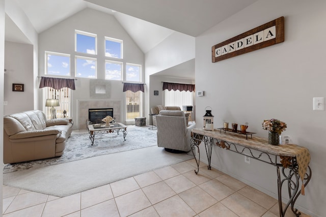 carpeted living room with a tile fireplace, a wealth of natural light, tile patterned floors, and high vaulted ceiling