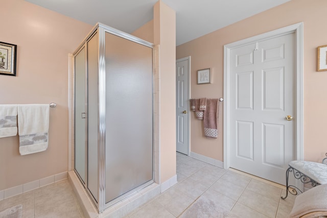 bathroom with baseboards, tile patterned flooring, and a stall shower