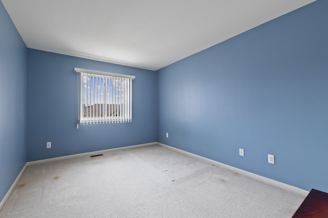 spare room with visible vents, carpet flooring, and baseboards