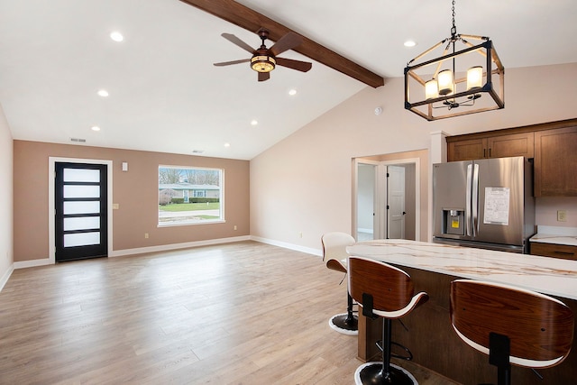 kitchen with light wood finished floors, stainless steel fridge, visible vents, ceiling fan with notable chandelier, and pendant lighting