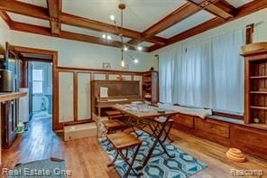 dining area with coffered ceiling, wood finished floors, and beamed ceiling