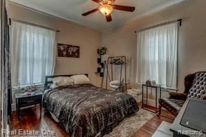 bedroom with wood finished floors and multiple windows