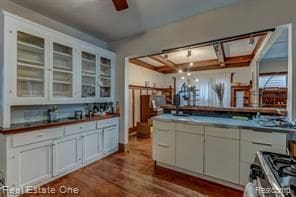 kitchen featuring ceiling fan, range, white cabinetry, dark wood-style floors, and glass insert cabinets