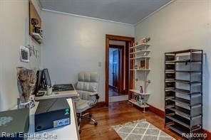 office space with crown molding, baseboards, and wood finished floors