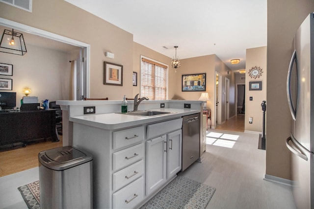 kitchen with a sink, visible vents, light wood-style floors, an island with sink, and appliances with stainless steel finishes