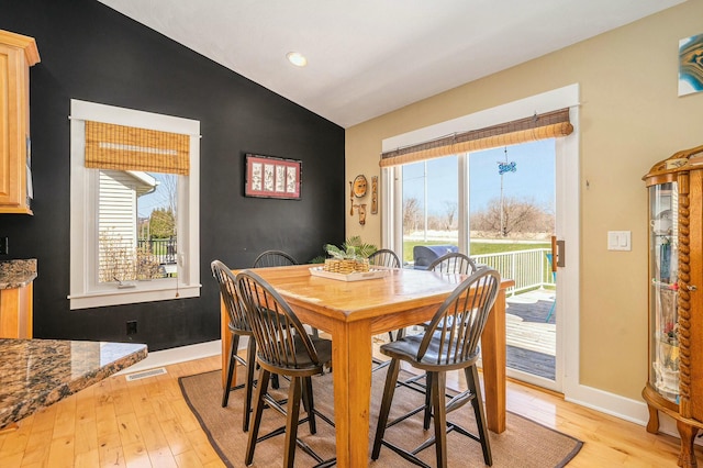 1332 Fluorite Ave, Zeeland, MI 49464 - dining room featuring light wood-style floors, vaulted ceiling, visible vents, and a wealth of natural light