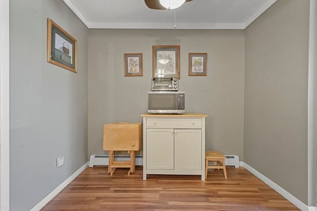 dining space with ceiling fan, light wood-style flooring, a baseboard heating unit, and baseboards