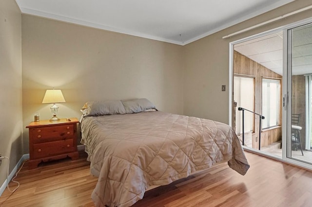 bedroom with wood finished floors, access to exterior, and crown molding