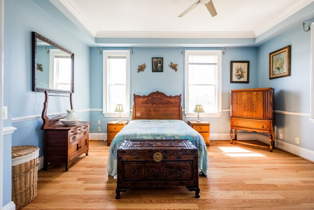 bedroom with light wood finished floors, ornamental molding, multiple windows, and baseboards