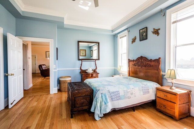 bedroom featuring wood finished floors, crown molding, and a ceiling fan