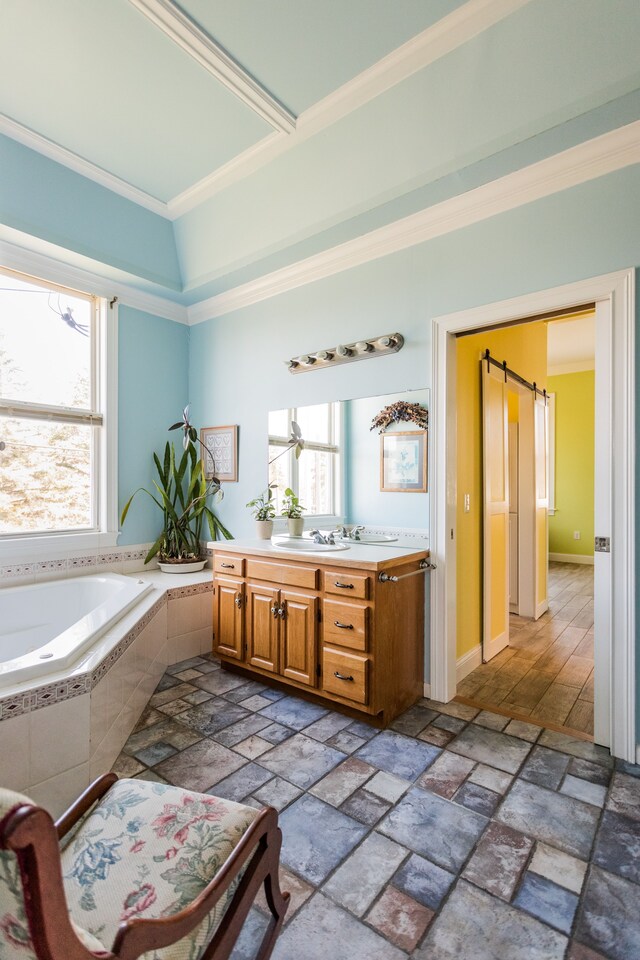 full bath with crown molding, a bath, vanity, and stone tile floors