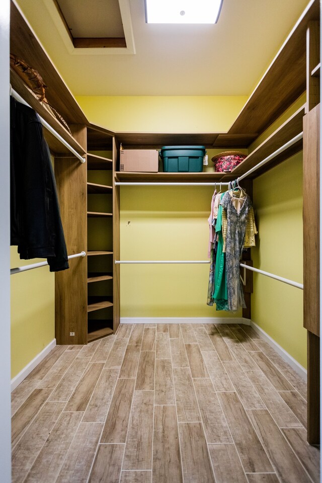 spacious closet featuring wood finished floors and attic access