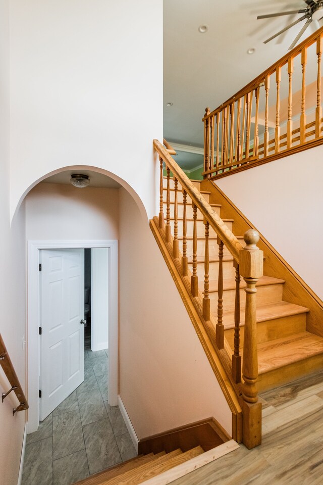 staircase with arched walkways, baseboards, a ceiling fan, and recessed lighting