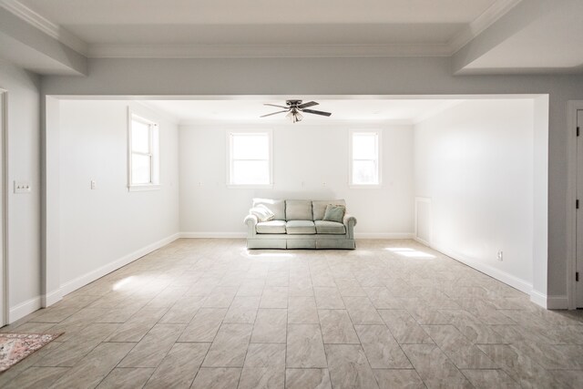 unfurnished living room featuring a ceiling fan, ornamental molding, and baseboards