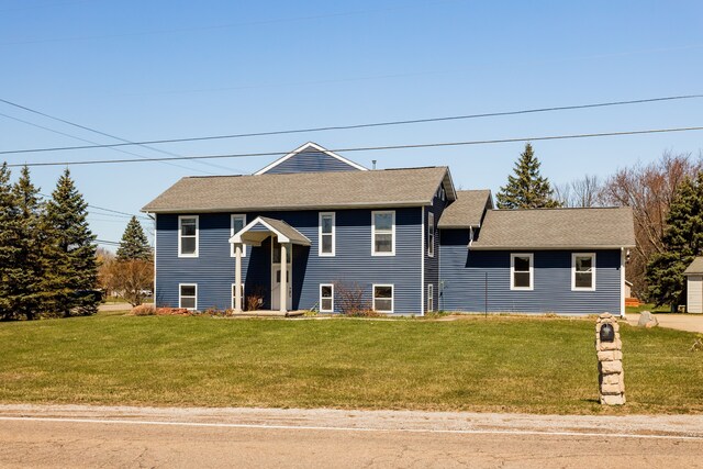 bi-level home with a front lawn and a shingled roof