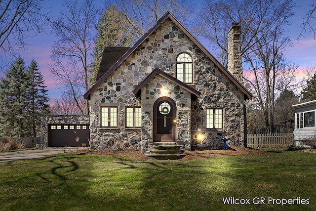 view of front of home featuring stone siding, a lawn, a chimney, and fence