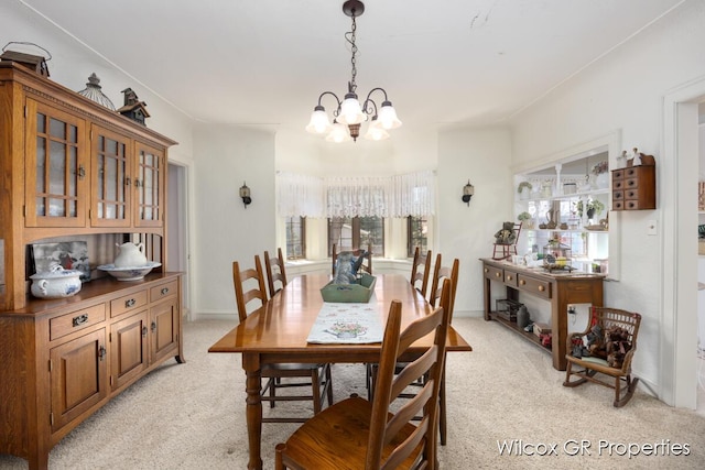dining room with light carpet, an inviting chandelier, and a wealth of natural light