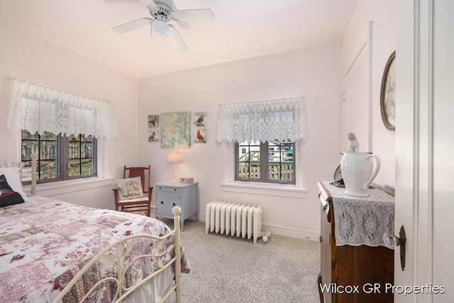 carpeted bedroom with radiator and a ceiling fan