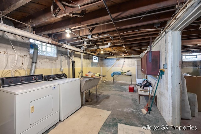 below grade area with washer and dryer, a wealth of natural light, and a sink