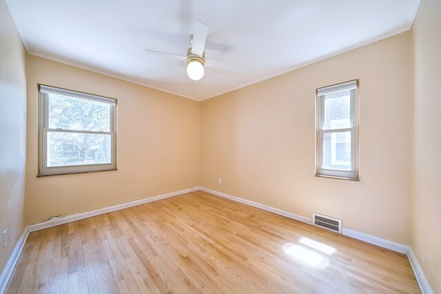 unfurnished room with visible vents, light wood-style floors, ceiling fan, and a healthy amount of sunlight