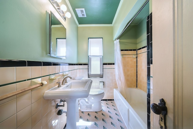 bathroom with shower / bath combination with curtain, tile walls, tile patterned flooring, toilet, and ornamental molding