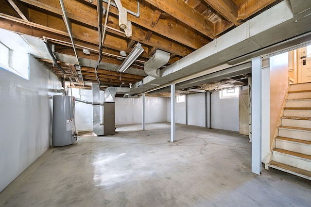 basement featuring heating unit, stairway, and gas water heater