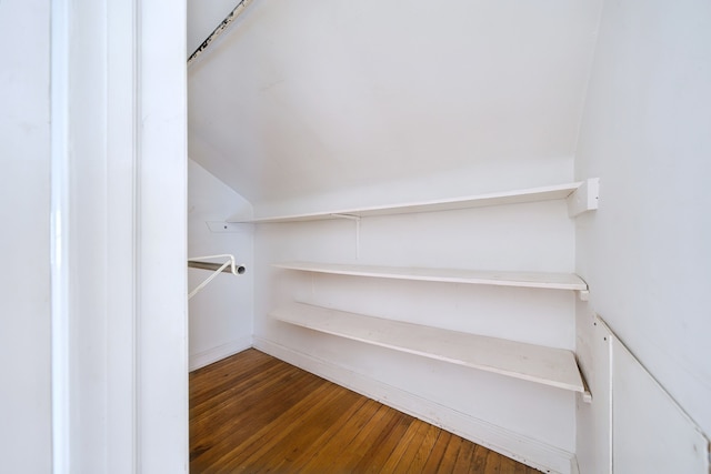 walk in closet featuring wood-type flooring and vaulted ceiling