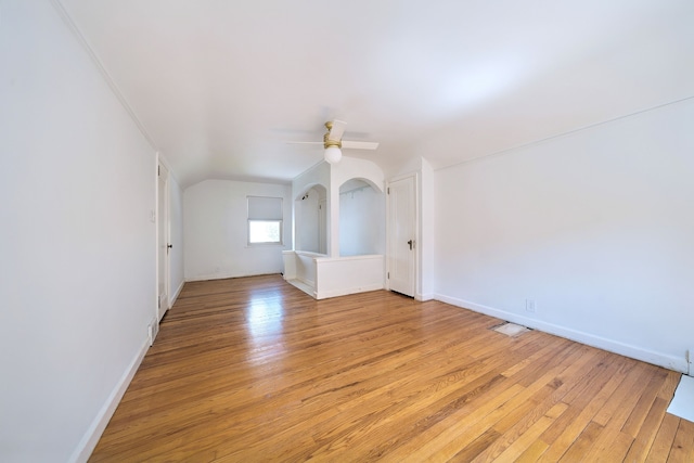 bonus room featuring light wood-style floors, baseboards, ceiling fan, and vaulted ceiling