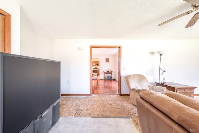 living area with ceiling fan, light carpet, and baseboards
