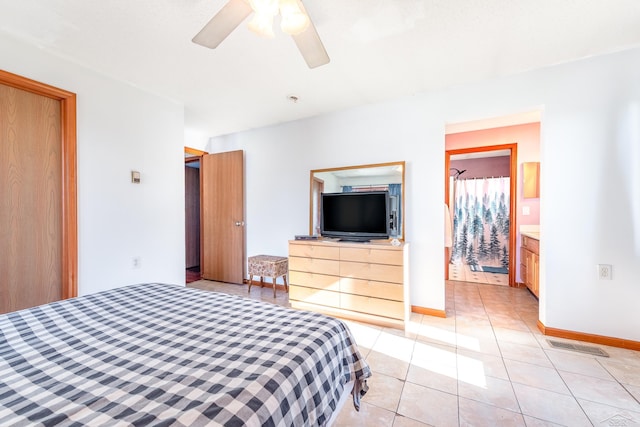 bedroom featuring visible vents, a ceiling fan, light tile patterned floors, baseboards, and ensuite bathroom