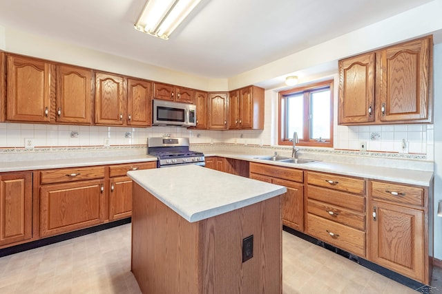 kitchen featuring light floors, brown cabinets, appliances with stainless steel finishes, and a sink