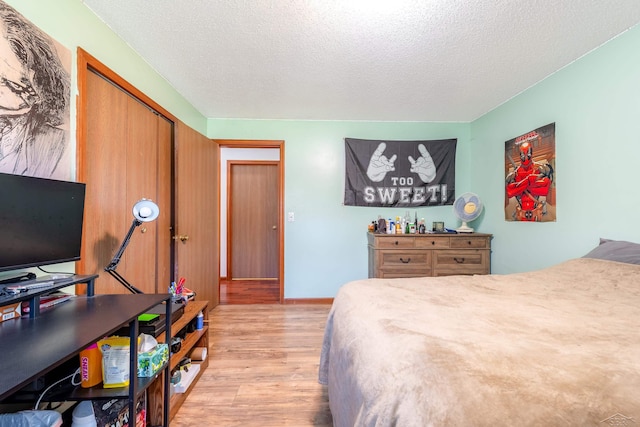 bedroom featuring light wood-type flooring and a textured ceiling