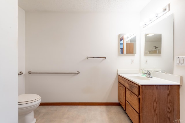 bathroom with baseboards, toilet, and vanity