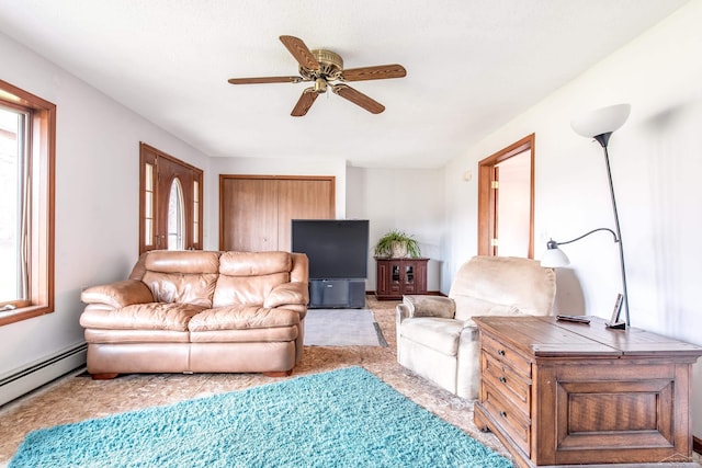carpeted living room featuring baseboard heating, a wealth of natural light, and a ceiling fan