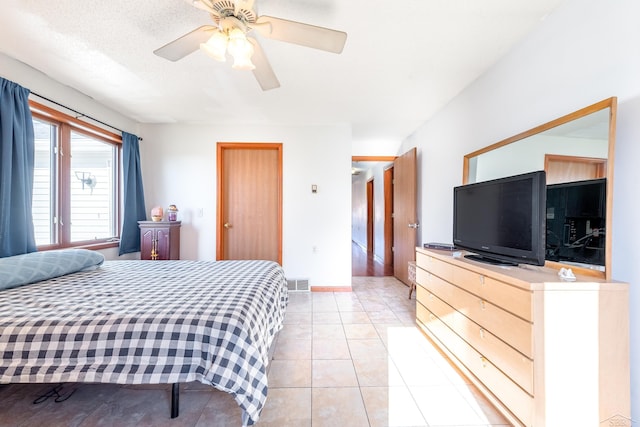bedroom featuring visible vents, baseboards, ceiling fan, and light tile patterned floors