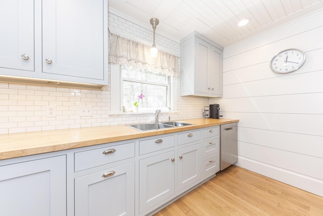 kitchen featuring wood counters, dishwasher, a sink, and tasteful backsplash