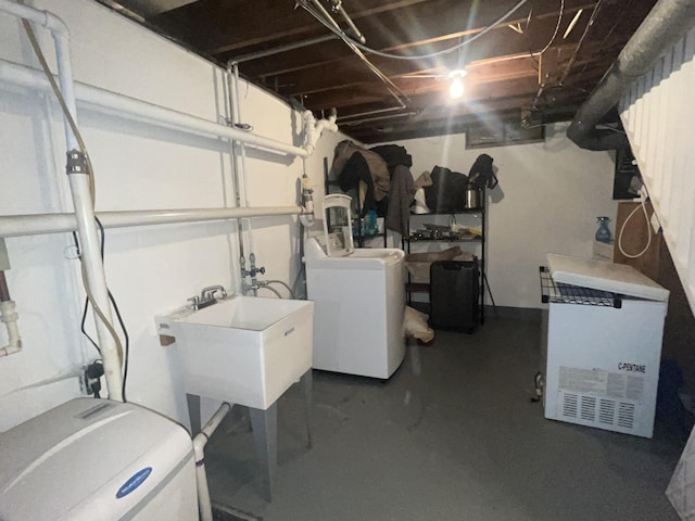 unfinished basement with independent washer and dryer and a sink