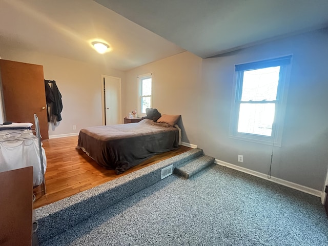 bedroom featuring lofted ceiling, baseboards, and visible vents
