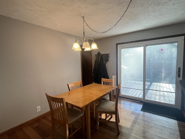 303 Sydelle Ave, Kalamazoo, MI 49006 - dining area featuring wood finished floors, a chandelier, and a textured ceiling
