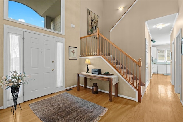 4435 Driftwood Dr, Commerce Twp, MI 48382 - foyer entrance featuring wood finished floors, stairway, and a high ceiling