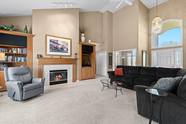 4435 Driftwood Dr, Commerce Twp, MI 48382 - living area featuring carpet flooring, high vaulted ceiling, a tile fireplace, ceiling fan, and a chandelier
