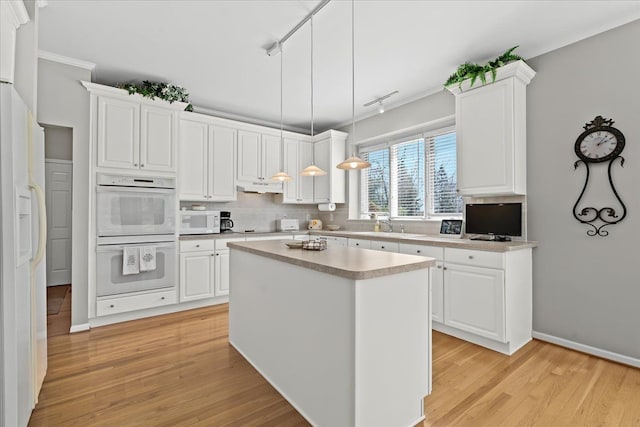 4435 Driftwood Dr, Commerce Twp, MI 48382 - kitchen with white appliances, light wood-style floors, under cabinet range hood, white cabinetry, and tasteful backsplash