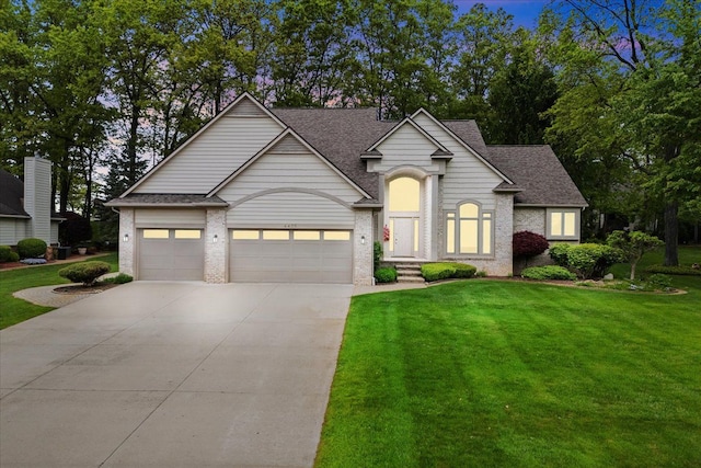4435 Driftwood Dr, Commerce Twp, MI 48382 - traditional-style home with concrete driveway, a front yard, a garage, roof with shingles, and brick siding