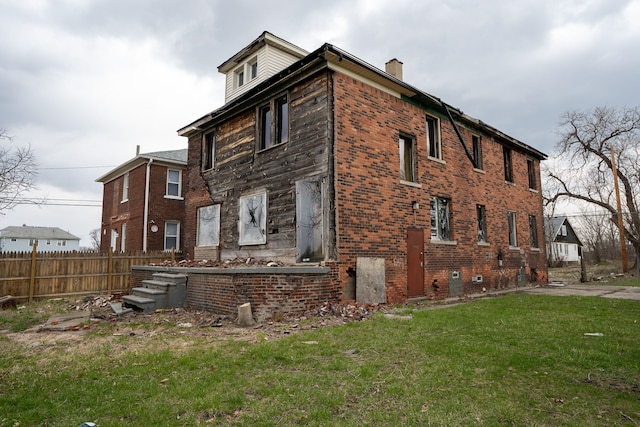 view of property exterior with a chimney and brick siding