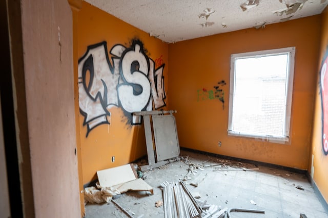 unfurnished room with a textured ceiling