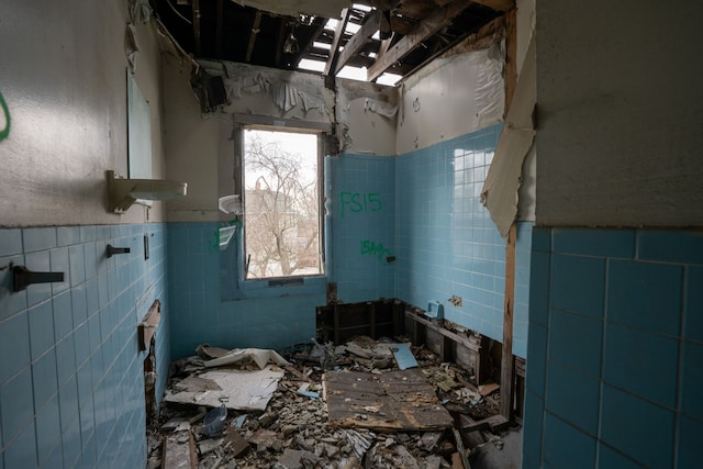 miscellaneous room with wainscoting and tile walls