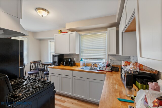 14725 Agnes Ave, Eastpointe, MI 48021 - kitchen featuring a sink, wooden counters, black appliances, decorative backsplash, and light wood finished floors