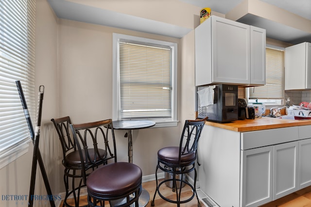 14725 Agnes Ave, Eastpointe, MI 48021 - kitchen featuring white cabinets, a sink, baseboards, wood counters, and tasteful backsplash